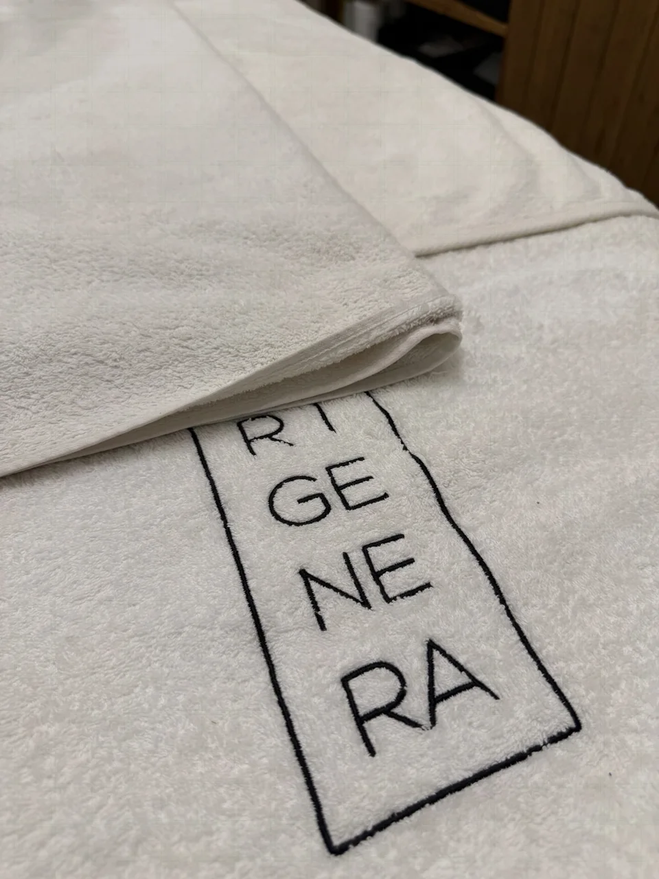 Dettaglio reale del centro GL: asciugamano con ricamo Rigenera